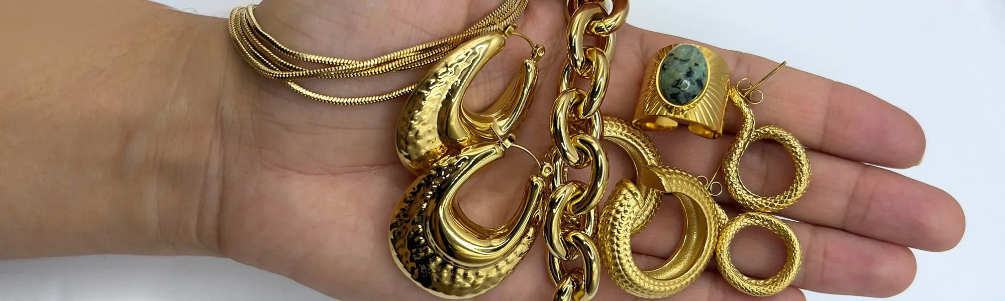 mano con muchas joyas bañadas en oro